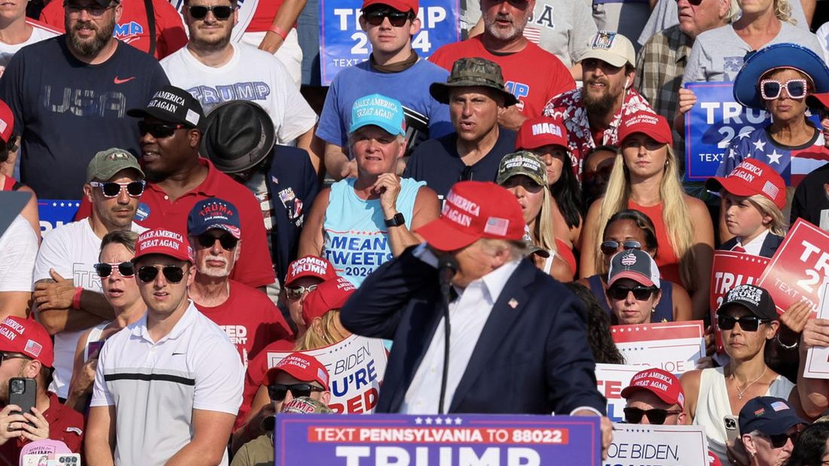 Donald Trump, calon presiden AS, memegang telinganya setelah mengalami luka akibat tembakan di rapat umum Pennsylvania, Sabtu malam, dengan darah terlihat di telinga dan pipinya.