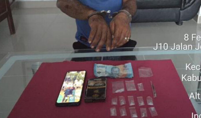 Tersangka pengedar narkotika jenis sabu berinisial RP (33) memperlihatkan barang bukti berupa 13 paket sabu siap edar, uang tunai, dan telepon genggam yang diamankan petugas Polsek Mandau, Polres Bengkalis, saat pengungkapan kasus di Kelurahan Balai Makam, Kecamatan Mandau, Kabupaten Bengkalis, Ahad (8/2/2026).