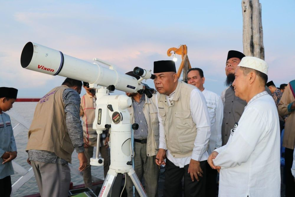 Petugas Kementerian Agama bersama ahli falak melakukan rukyatul hilal menggunakan teleskop untuk memantau kemunculan bulan penanda awal Ramadan.